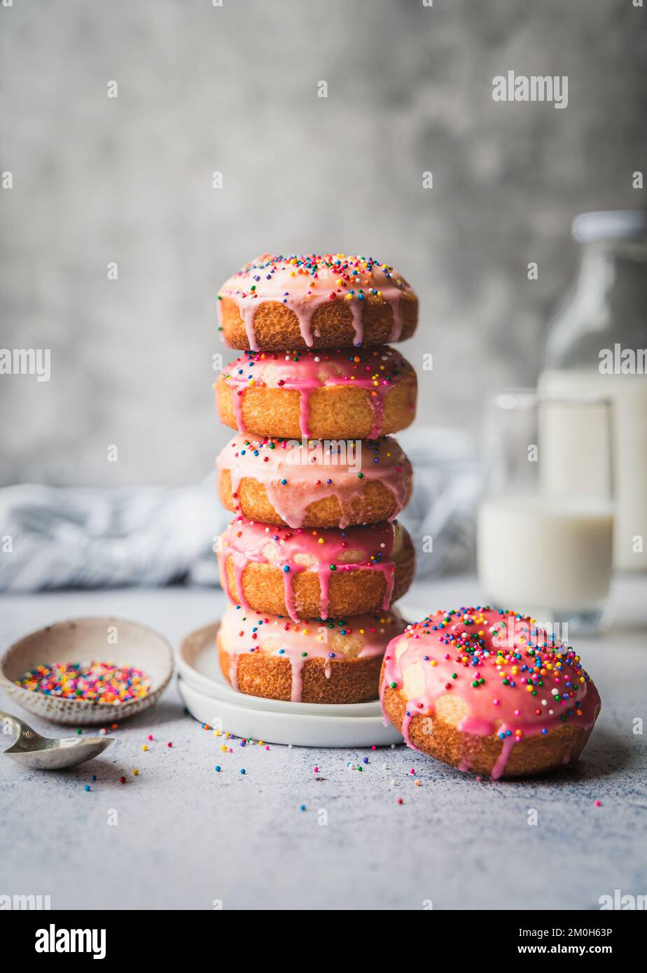 Stack of vanilla cake donuts with pink icing and sprinkles Stock Photo ...