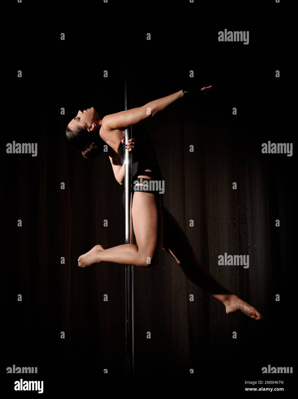 woman does pole dance sport at home Stock Photo