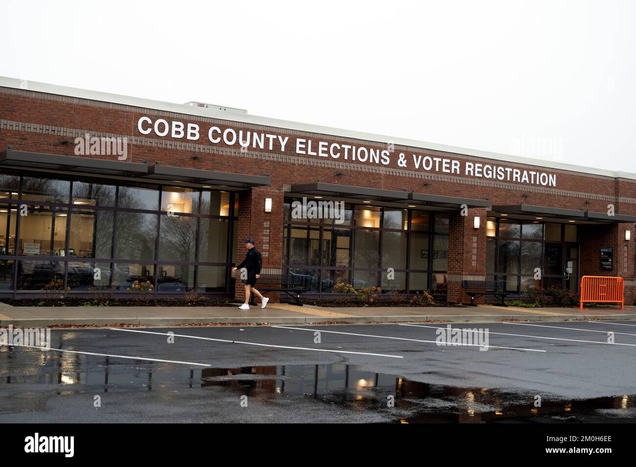 Marietta, Georgia, USA. 6th Dec, 2022. A voter leaves the Cobb County election office having just deposited his absentee ballot with an election official. Cobb County Superior Court Judge Kellie Hill has issued an order extending the deadline for certain absentee ballots to be returned to the Cobb Elections office for the December 6 runoff election.This was a consent order between the ACLU and Cobb County Board of Elections and Registration, citing a 'confluence of deadlines,'' including a holiday, a new state statute, and the Thanksgiving holiday that led to a delay in sending out some Stock Photo