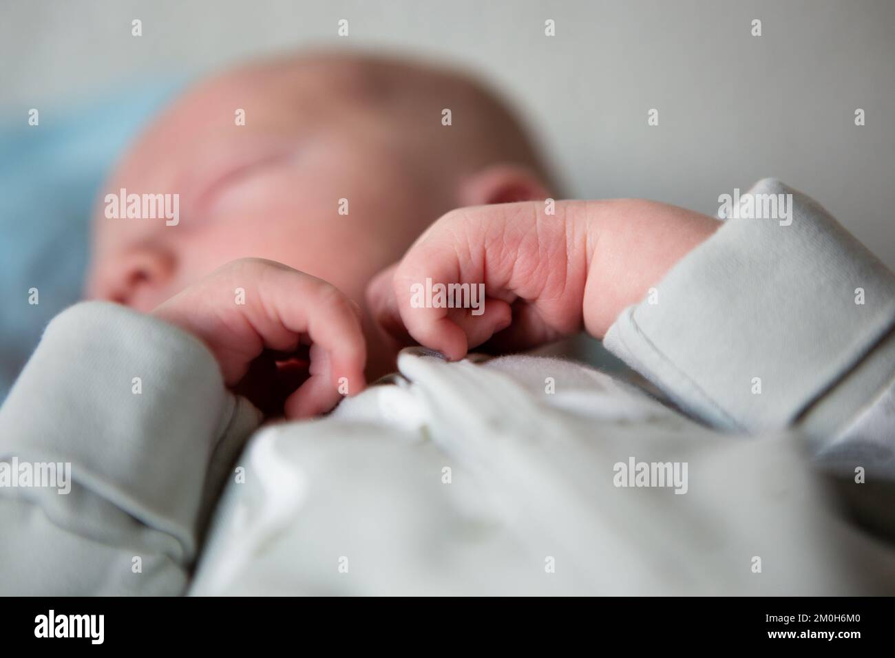 Close up of newborn baby's hands while sleeping in bed at home Stock Photo