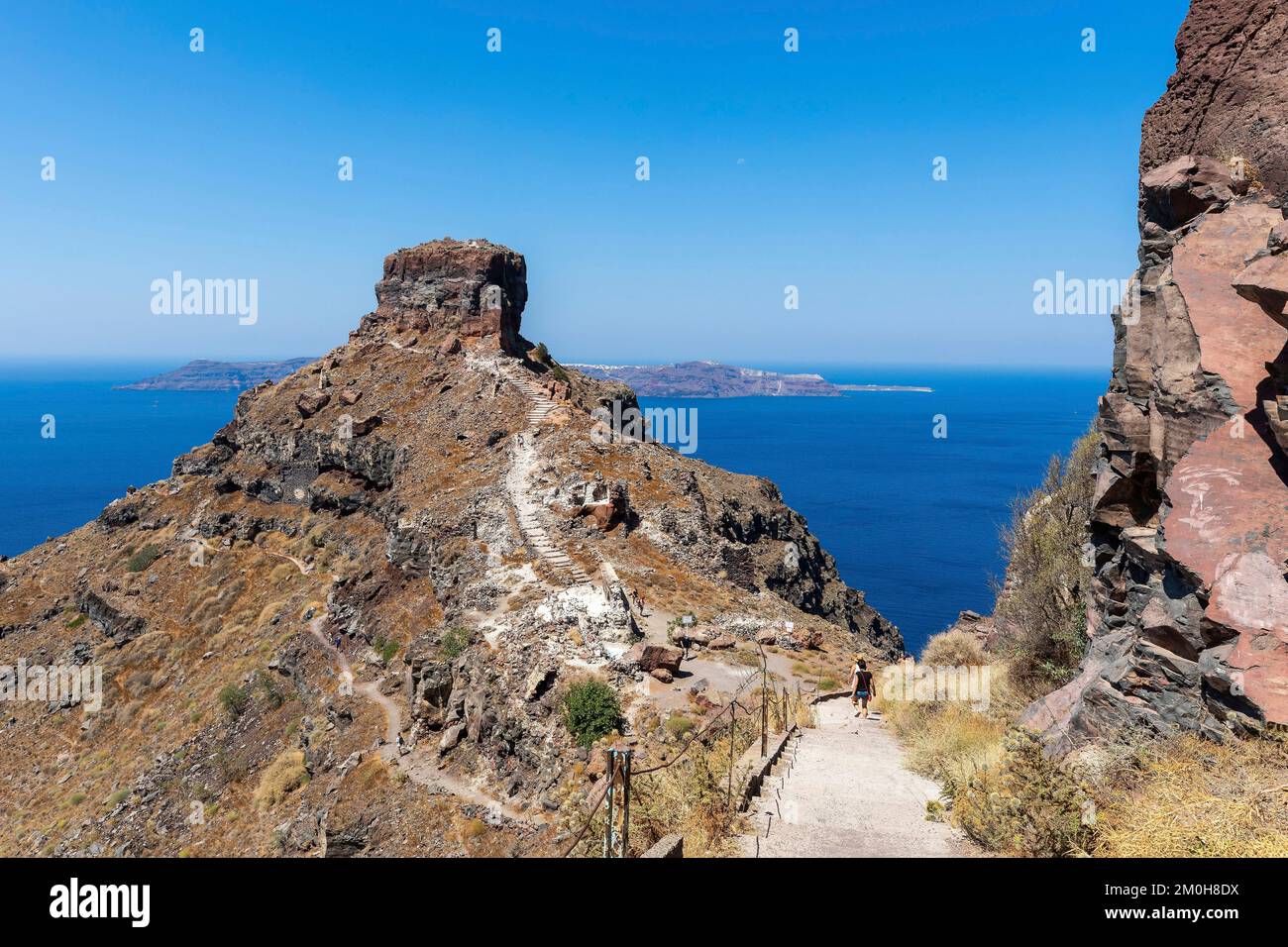 Greece, The Cyclades, Santorini Island (Thera or Thira), village of Fira, woman walking on the path to Skaros rock and ruins of the Venetian fortress of Skaros Stock Photo