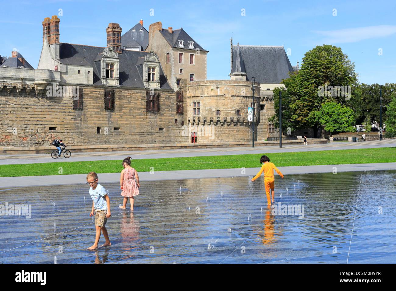 France, Loire Atlantique, Nantes, Elisa Mercoeur square , children playing with the water mirror designed by the architect Bruno Fortier with the castle of the Dukes of Brittany in the background Stock Photo