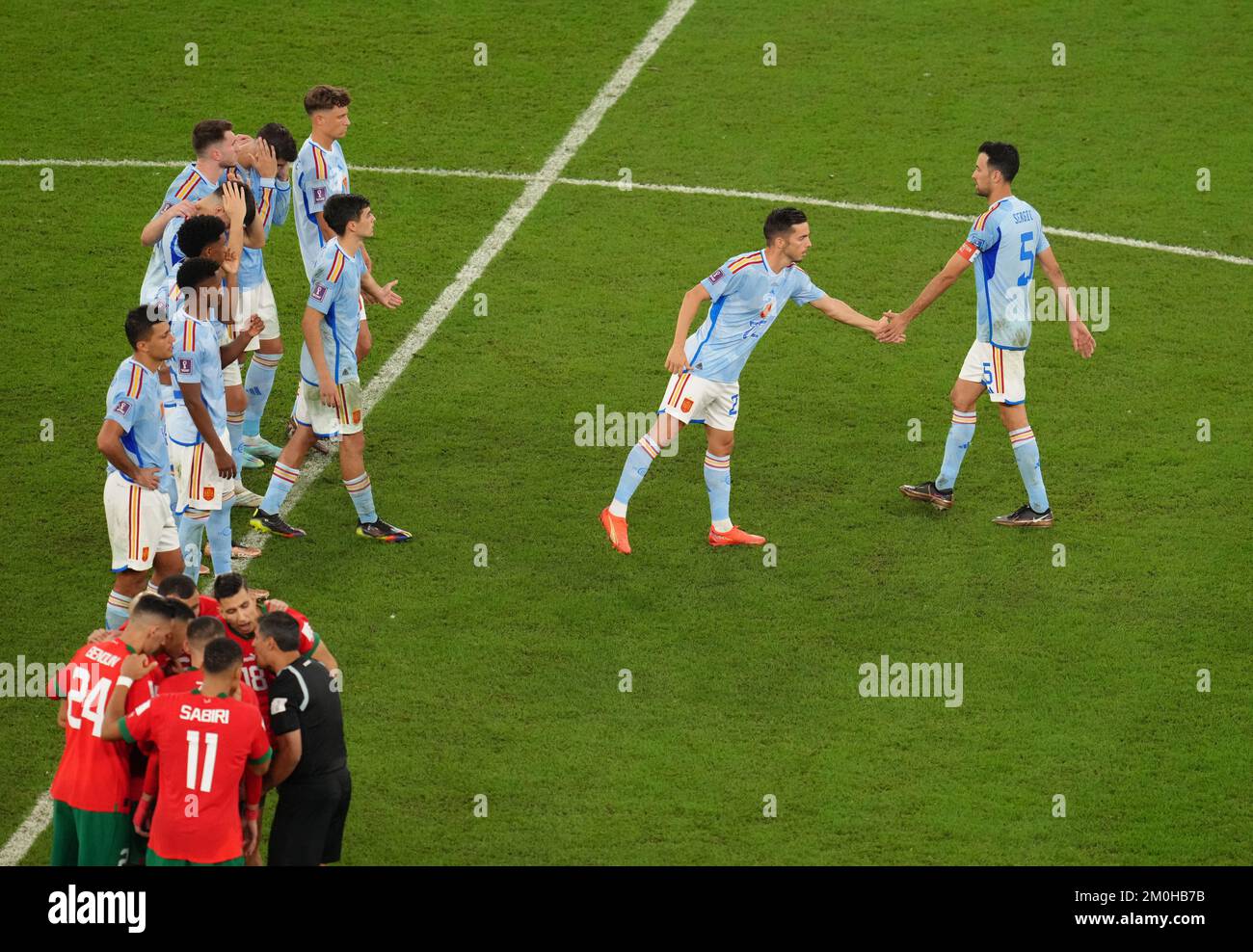 Spain's Sergio Busquets (right) walks back to the centre circle after missing during the penalty shoot-out in the FIFA World Cup Round of Sixteen match at the Education City Stadium in Al-Rayyan, Qatar. Picture date: Tuesday December 6, 2022. Stock Photo