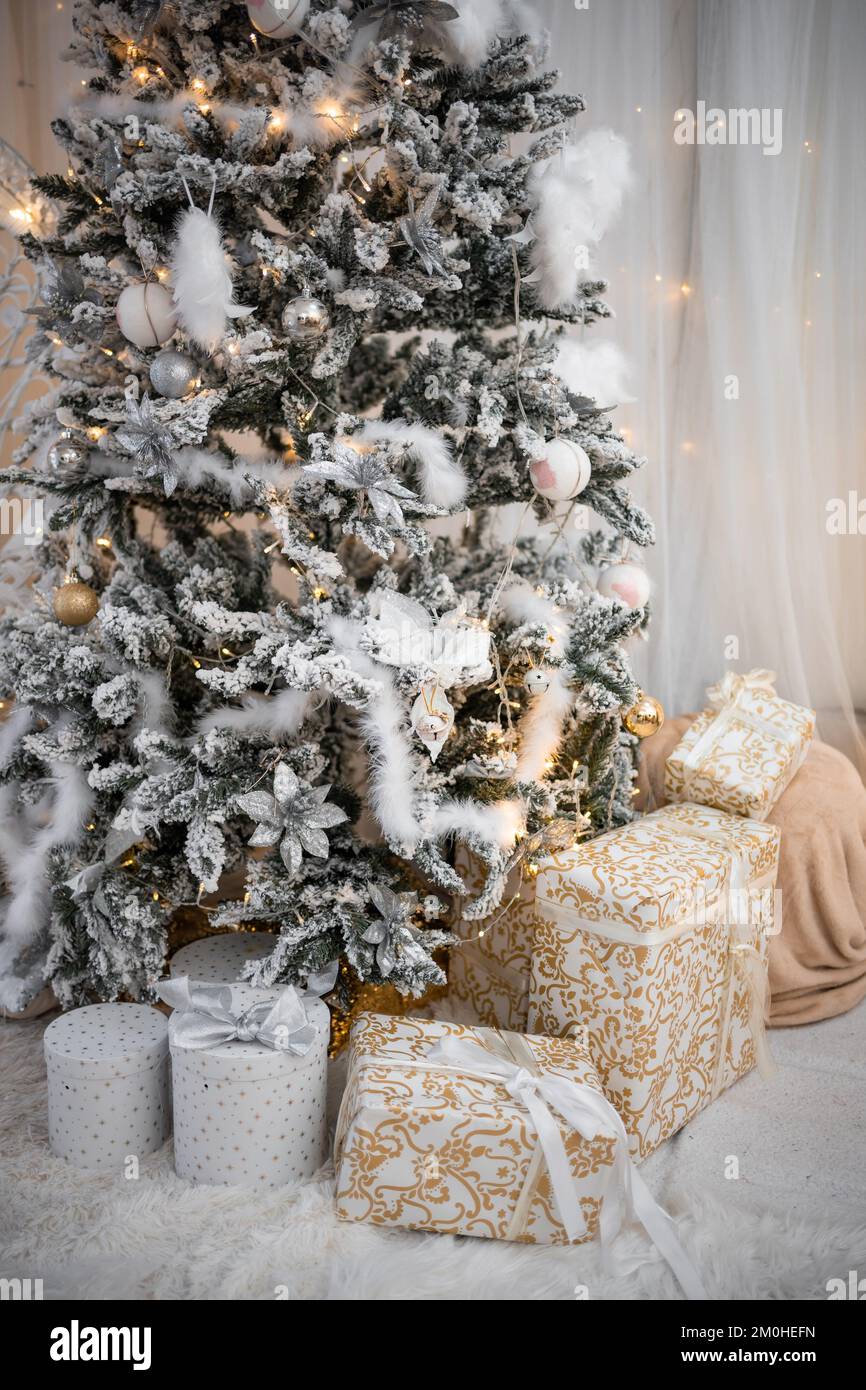 Beautiful Christmas gift boxes on floor near fir tree in room Stock ...