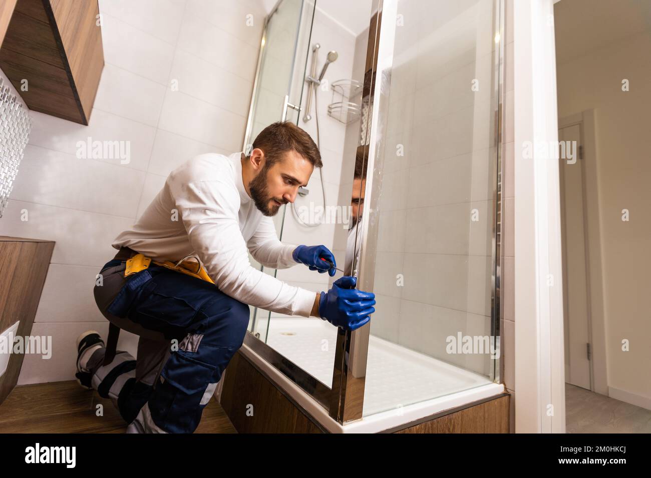 Plumber installing a shower cabin in bathroom Stock Photo Alamy