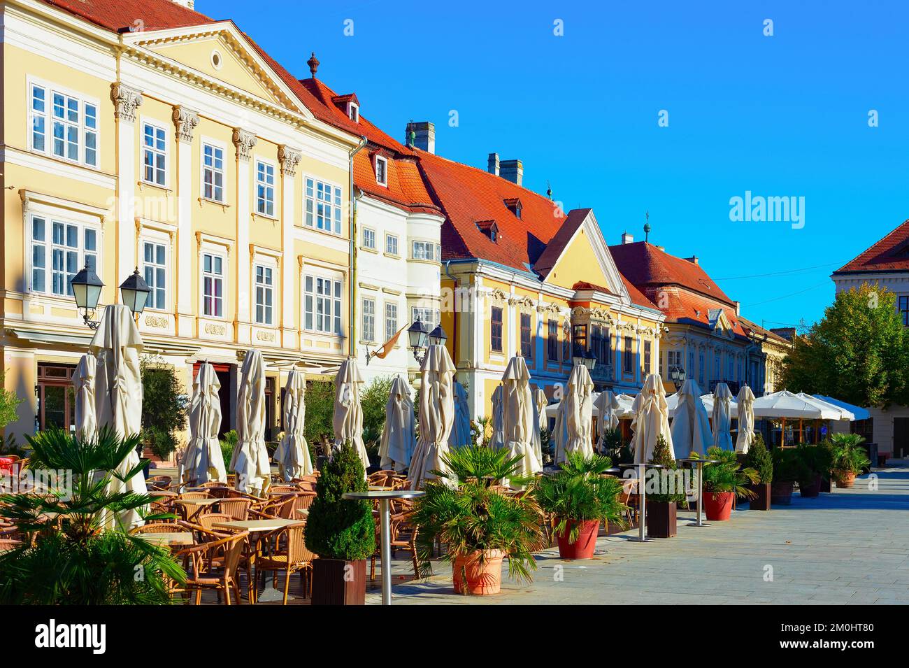 Morning old town view, street terraces of restaurants, green plants and historical architecture, Gyor, Hungary Stock Photo