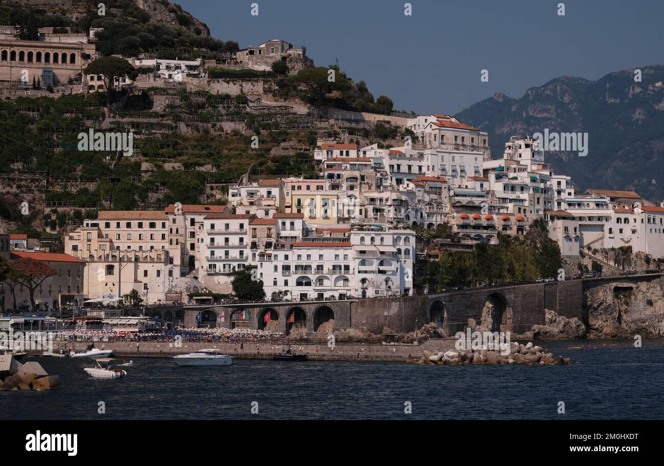 A view of Amalfi town towards the east side with the properties on the rising cliffs with the sea and harbour in the foreground. Stock Photo