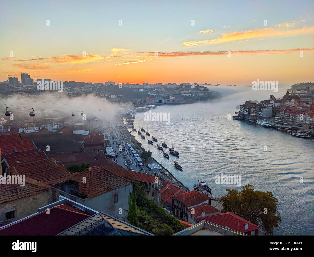 Porto cityscape from Gaia, fog coming by Douro river at sunset, cable car, Porto, Portugal Stock Photo