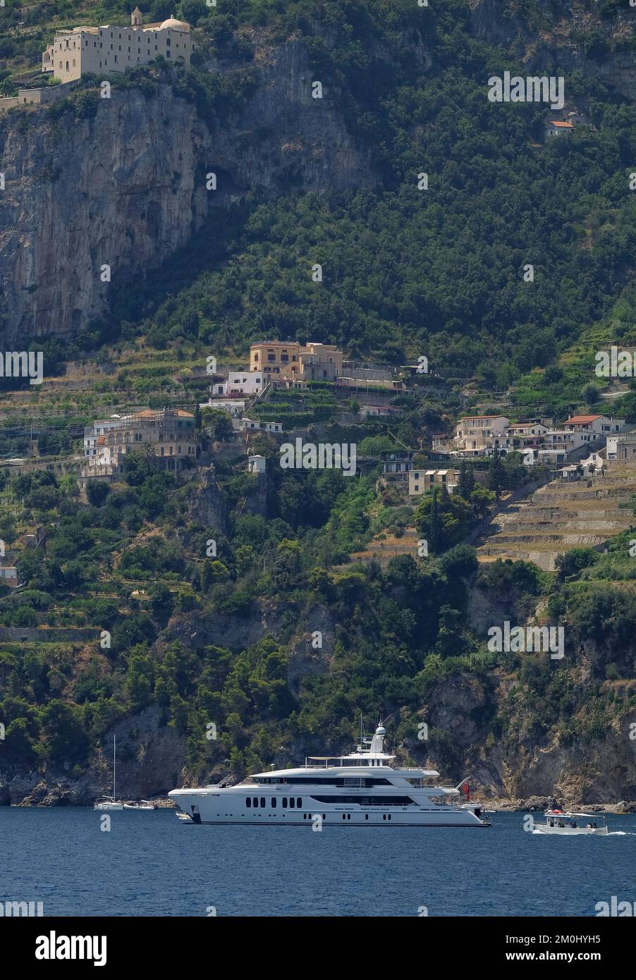 The Liquid Sky motor yacht moored of of the Amalfi coast Italy amongst the cliffside houses and rugged coastline. Stock Photo