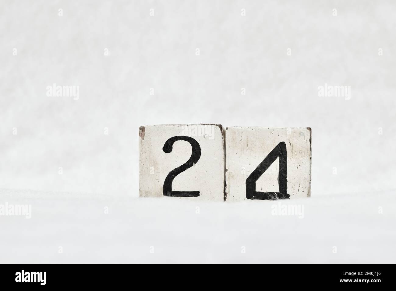 24 vintage wooden block calendar number on white snow background, copy