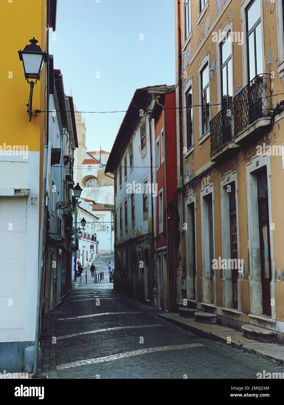 A vertical shot of the old narrow street of the city with old-style ...