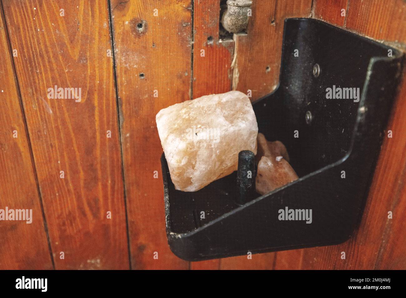 Rock salt for the horse on a shelf inside the horse stable Stock Photo