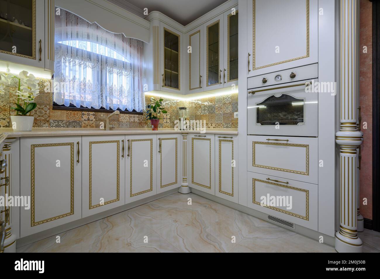 A beautiful kitchen with dark wood cabinets, marble countertops, chairs  sitting at the island, and stainless steel appliances. No brands or names  Stock Photo - Alamy