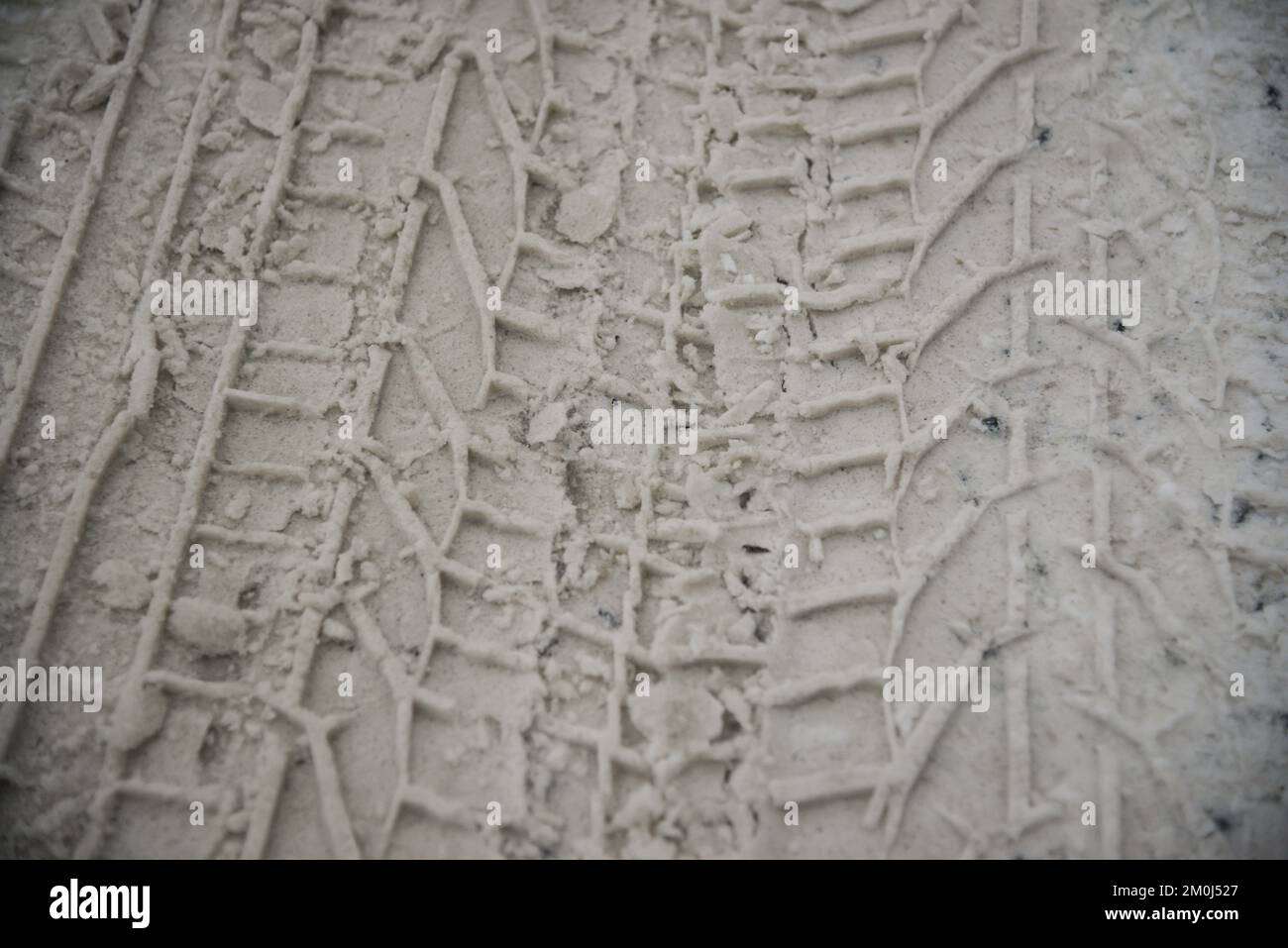 Snow tyre mark. Asphalt covered in snow. Dangerous road conditions. Car imprint on frozen ground. Tire trail on ice. Stock Photo
