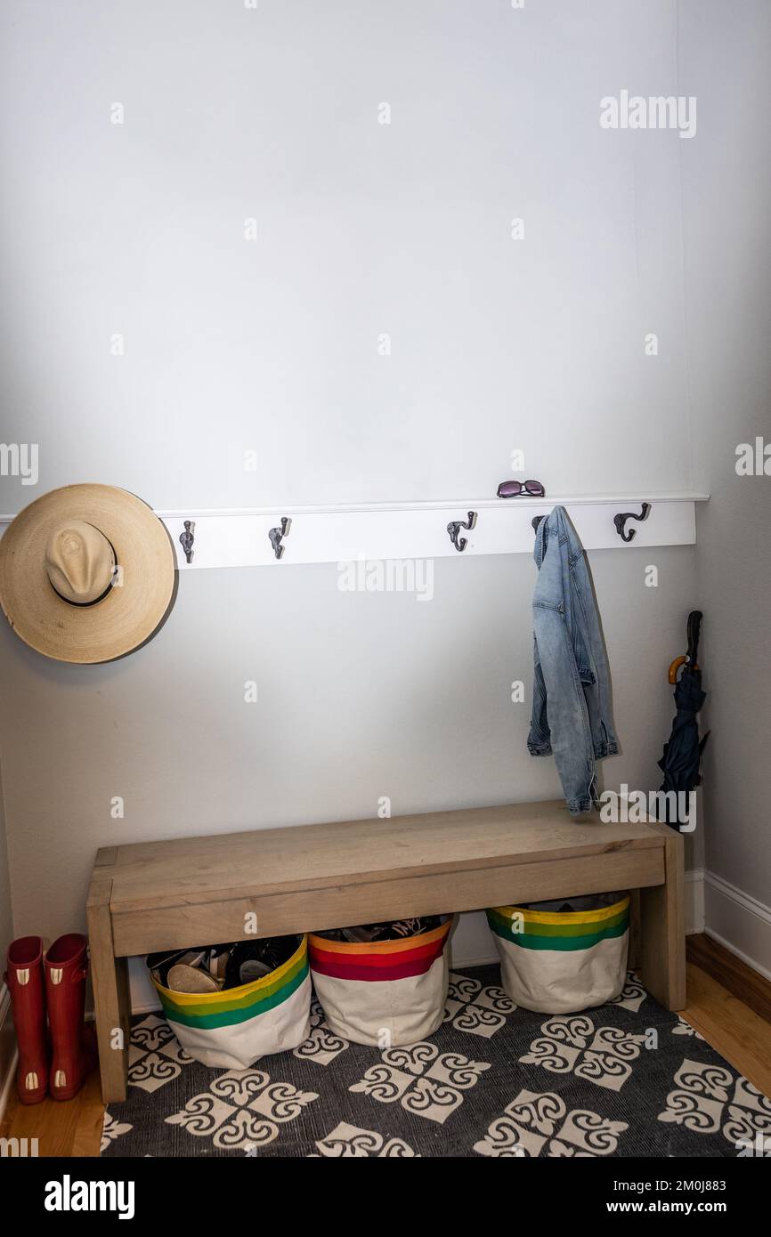A small entrance mudroom with a hooks for hanging jackets and hats