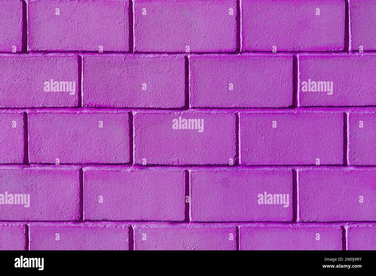 Purple pink lilac color paint wall brick blocks exterior facade texture background home abstract house. Stock Photo