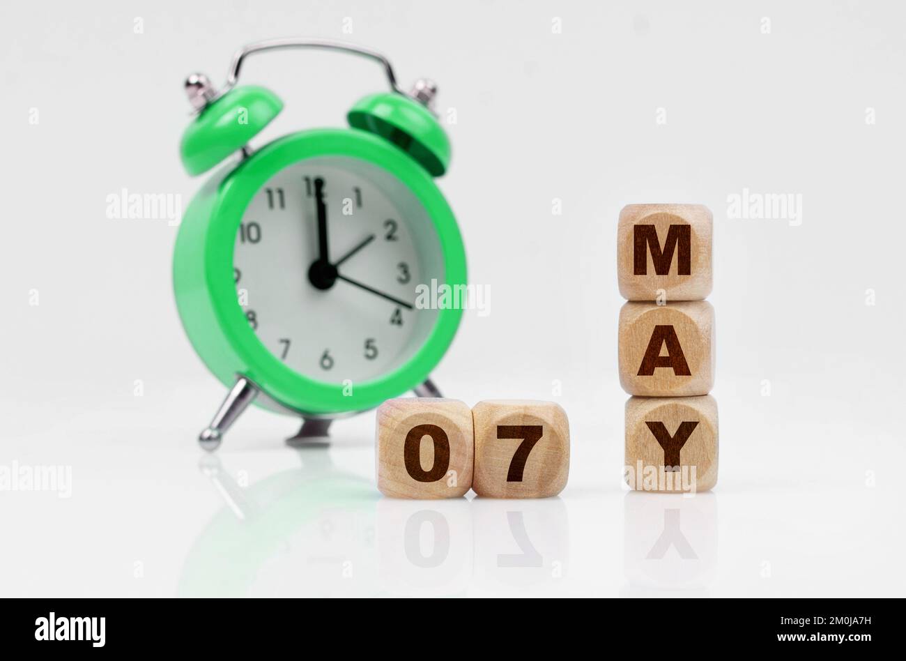 Business and holidays concept. On a white background there is an alarm clock and a calendar with the inscription - MAY 07 Stock Photo