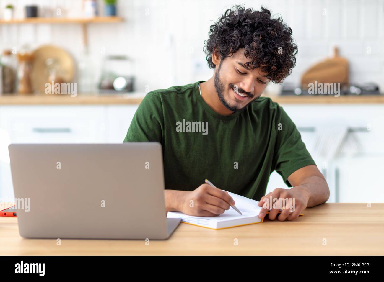 Successful student or freelancer sitting at workplace and working using laptop Distant work, e-learning concept Stock Photo