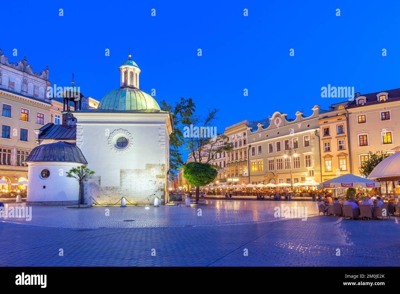 Main Market Square with restaurants and Church of St. Adalbert in downtown Krakow, Poland at twilight. Stock Photo