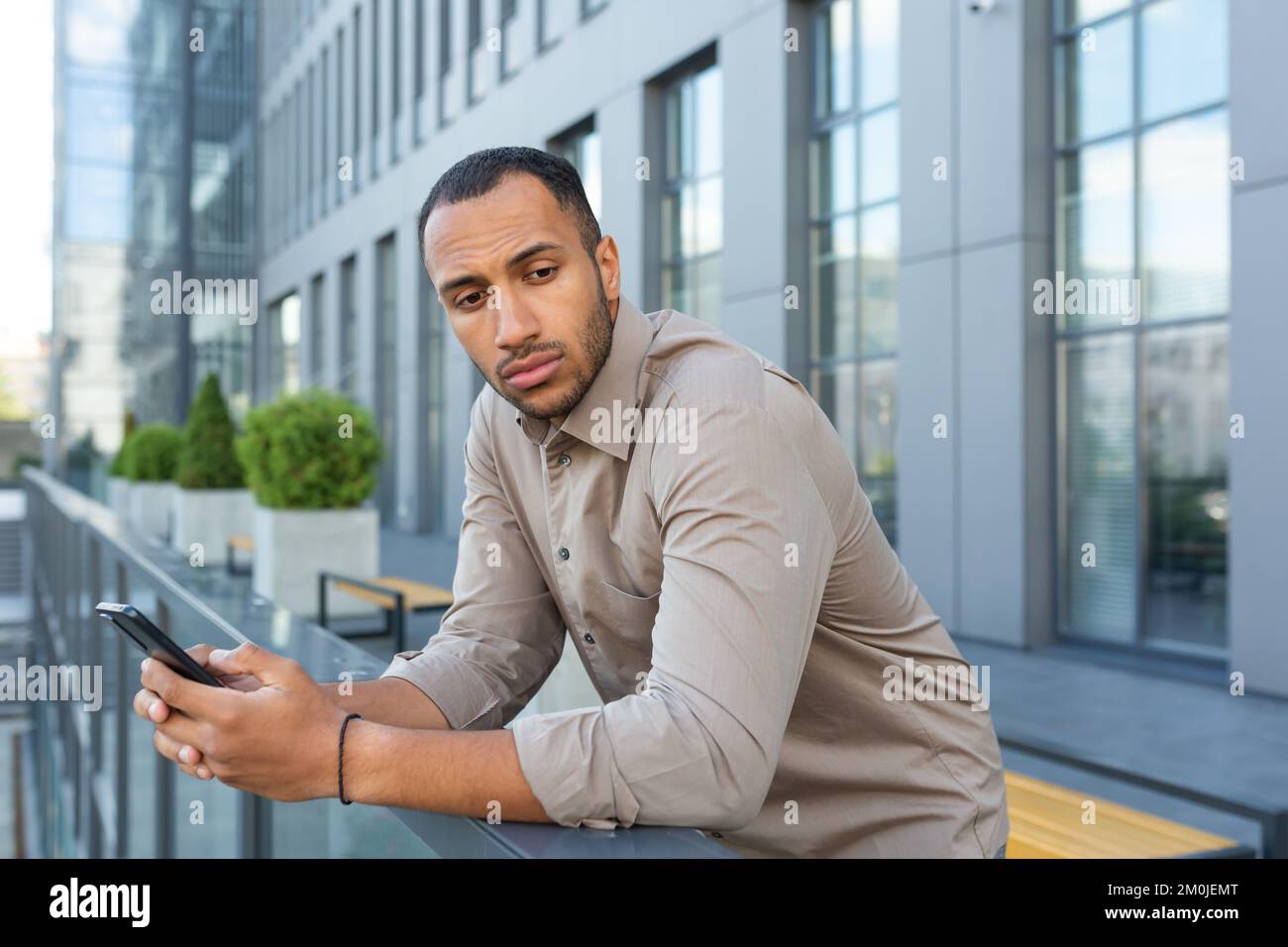 Serious thinking businessman outside office building pondering decision