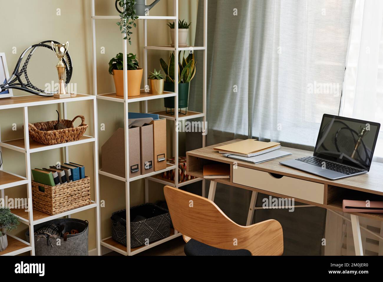 Background image of cozy home office workplace with wooden details and metal shelves with decor items, copy space Stock Photo