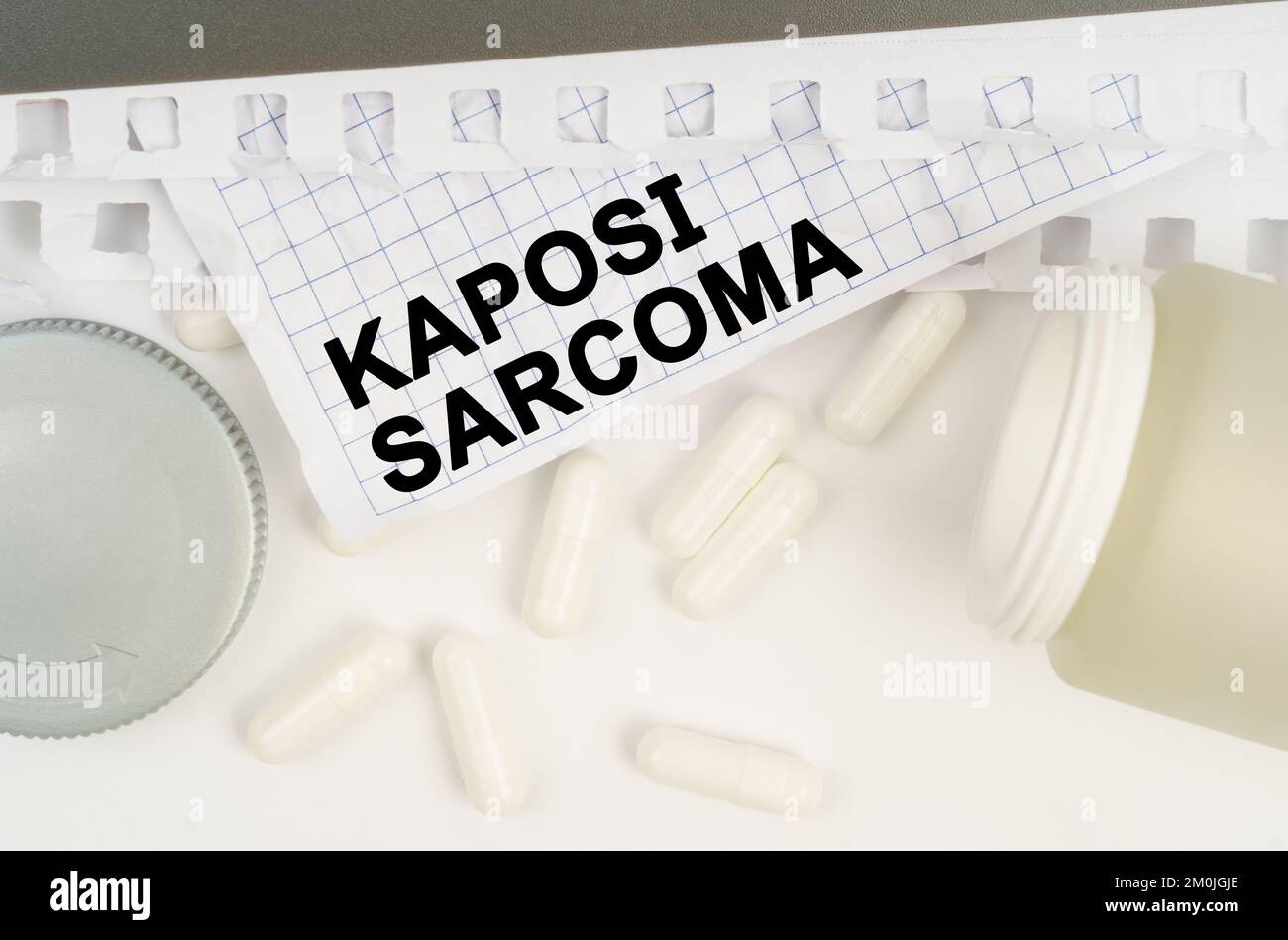 Medicine and health concept. On the table is an open jar of pills and a sheet of paper with the inscription - Kaposi sarcoma Stock Photo