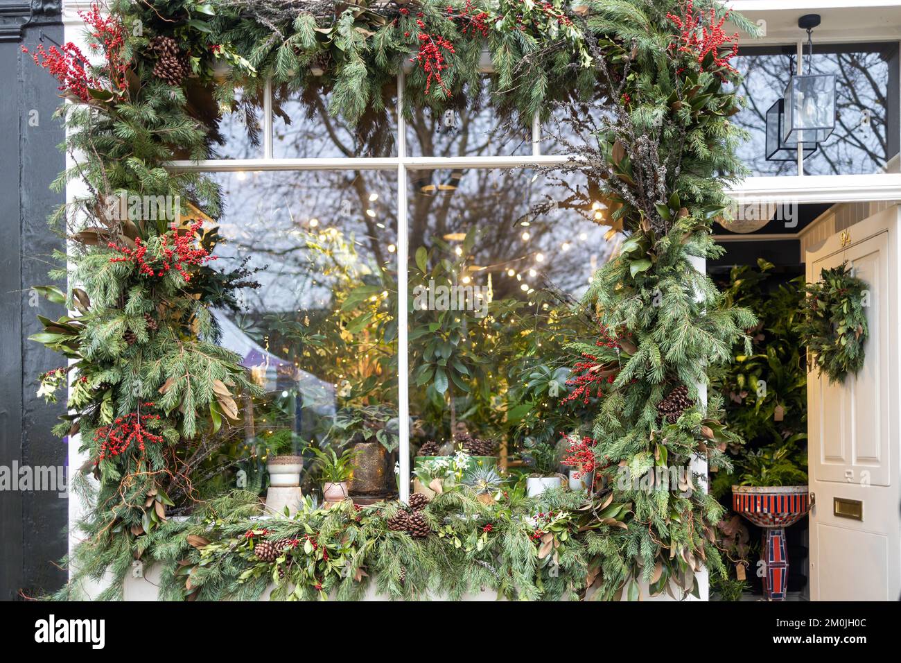 Shop window decorated around the perimeter with fir branches with red berries of St. John's wort and pine cones Stock Photo