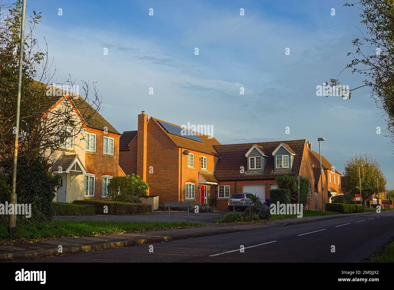 Modern luxury houses along a suburban road on a sunny autumn day Stock Photo