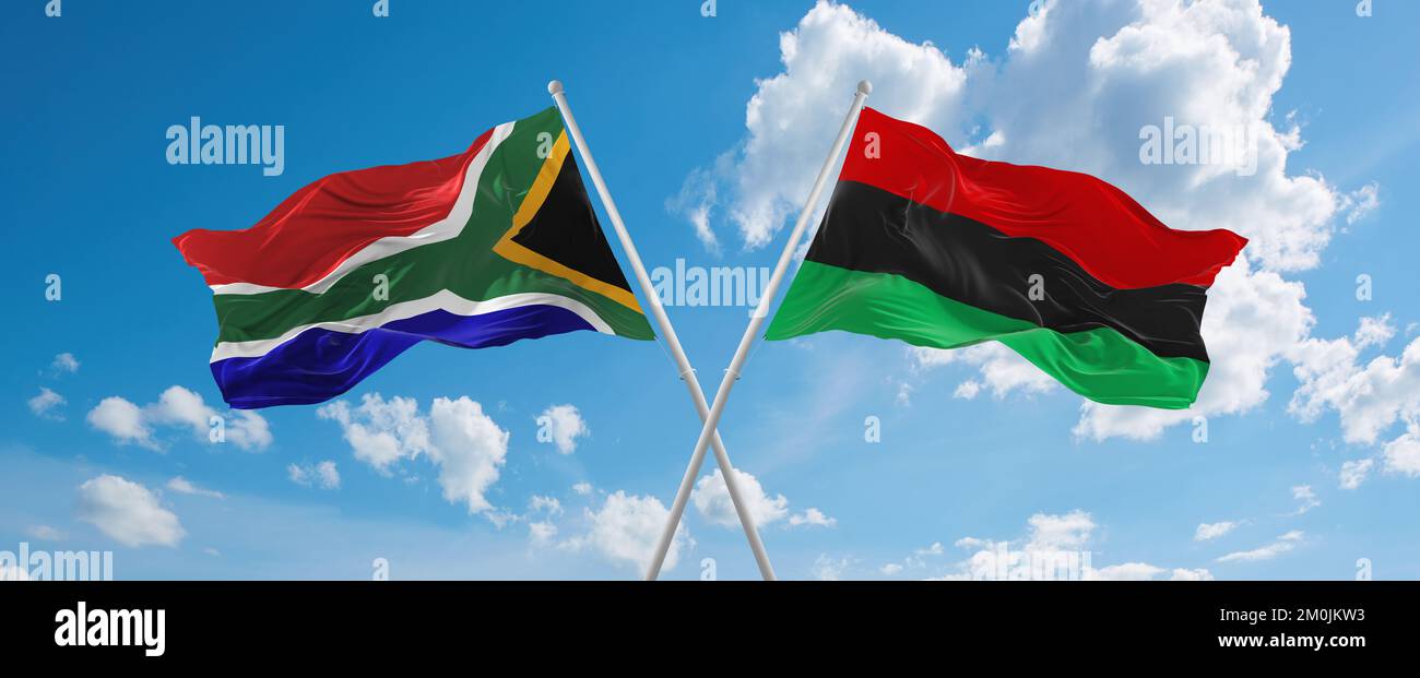 two crossed flags Pan-African and South Africa waving in wind at cloudy ...