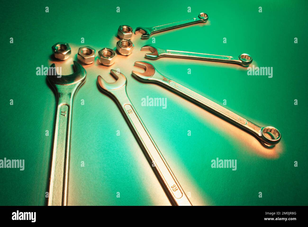 Spanners and Nuts on Green Background Stock Photo