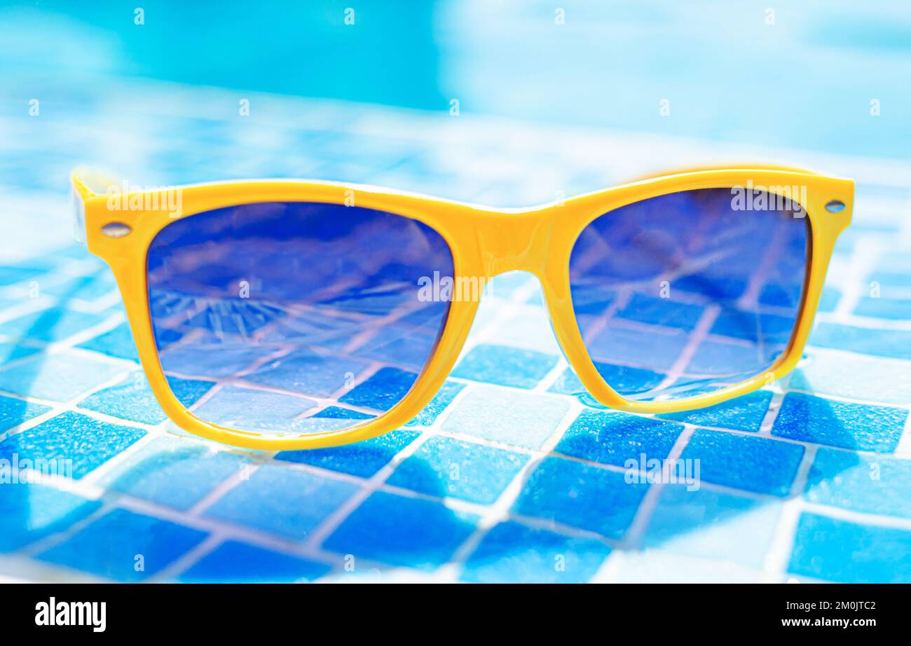 Yellow sunglasses on a background of a pool Stock Photo Alamy