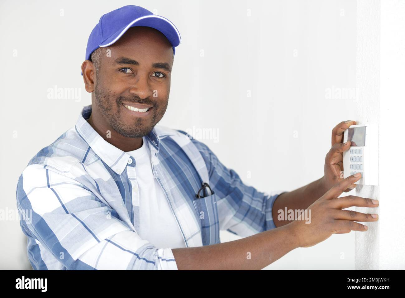 thermostat inspection and programming performed by hvac technician Stock Photo