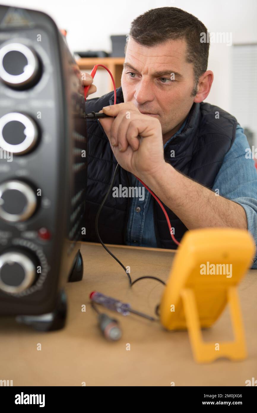 workman testing oven with a multimeter Stock Photo Alamy