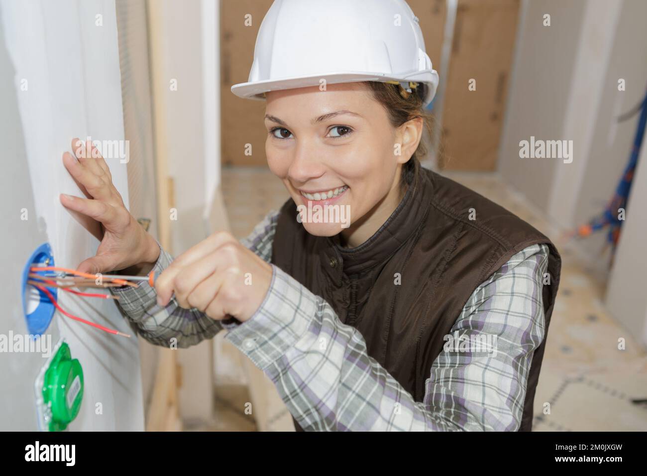 female electrician fixing socket electricity problem Stock Photo