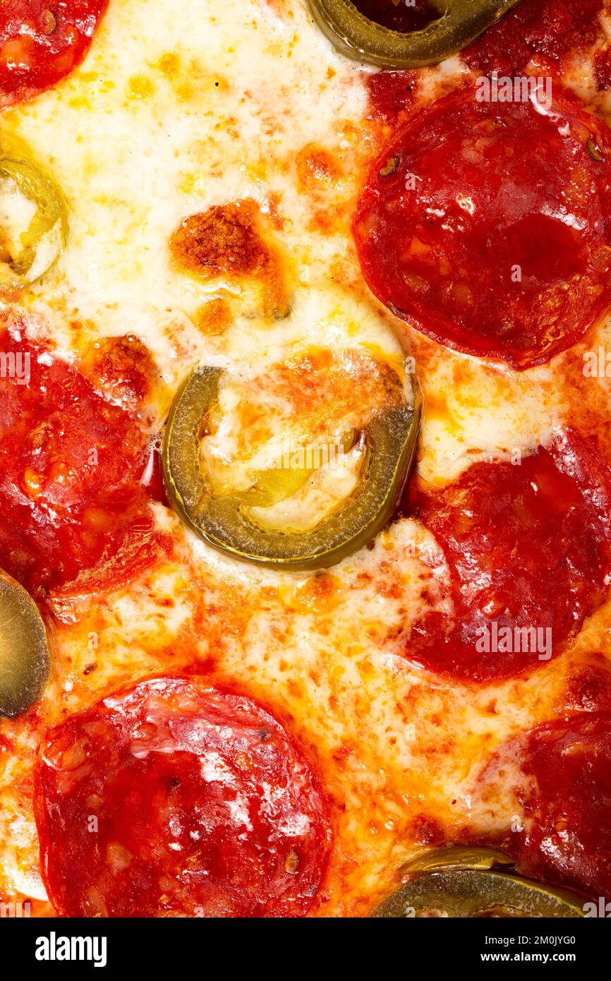 Salami pepperoni pizza texture with jalapeno as background. A close