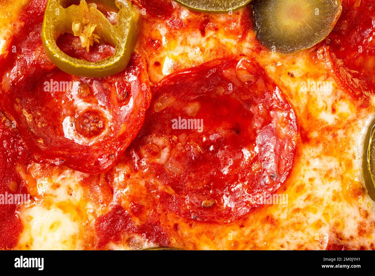 Salami pepperoni pizza texture with jalapeno as background. A close