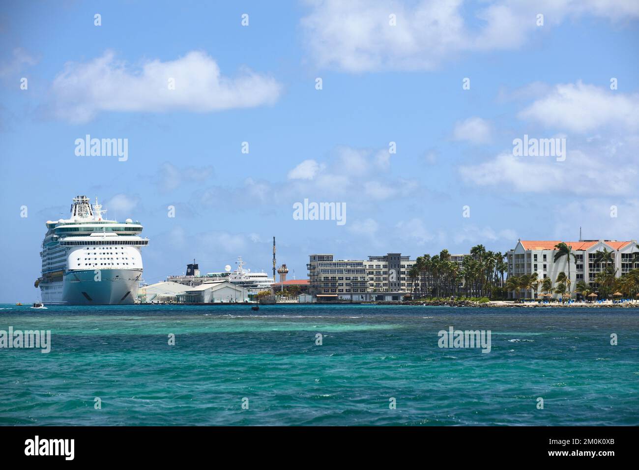 ORANJESTAD, ARUBA - JUNE 2, 2022: View of cruise ship docking at   terminal and on the right the Renaissance Ocean Suites Hotel in Oranjestad on Aruba Stock Photo