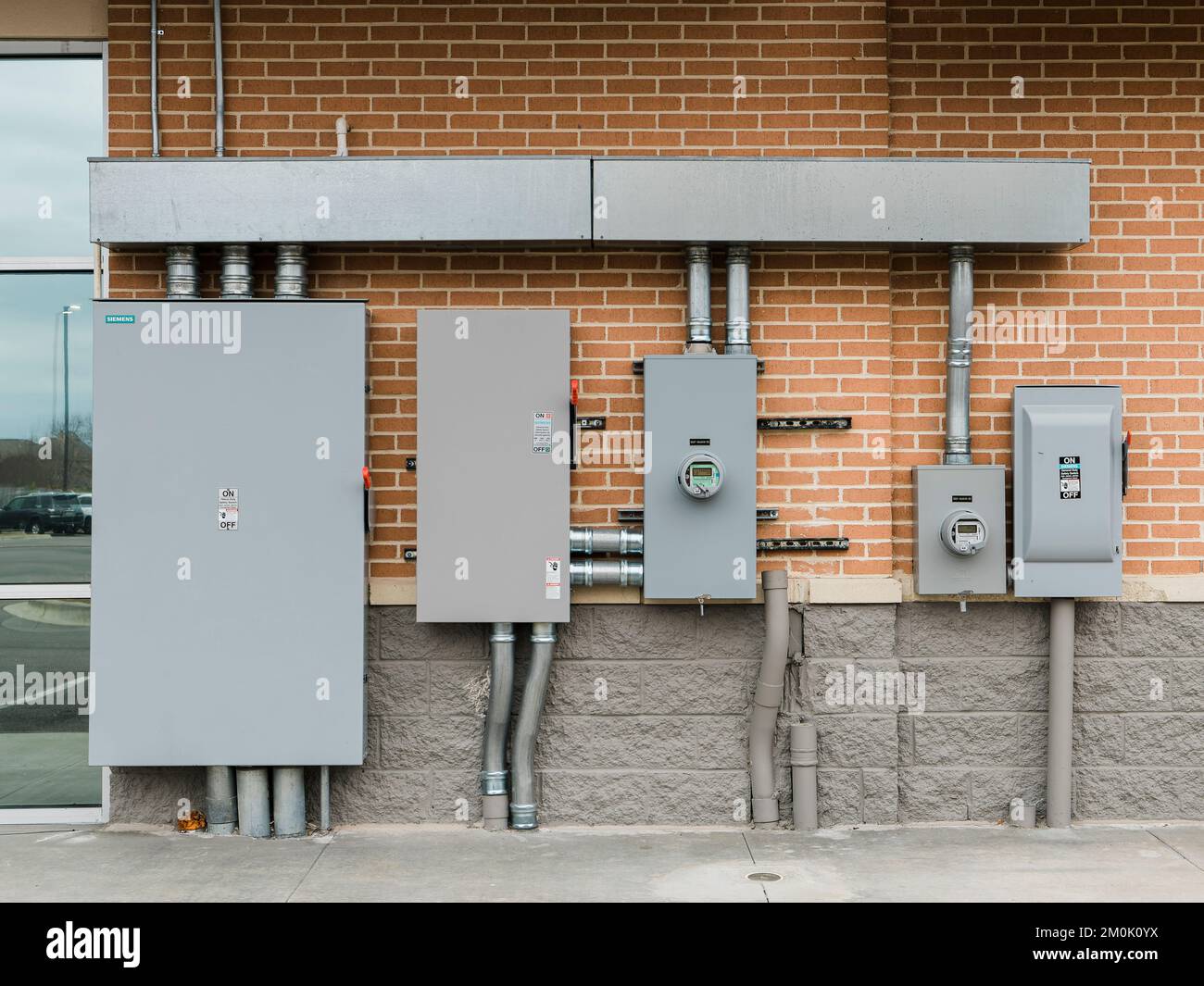 Row of commercial or industrial electrical boxes on the wall of a row of businesses in Pike Road Alabama, USA. Stock Photo