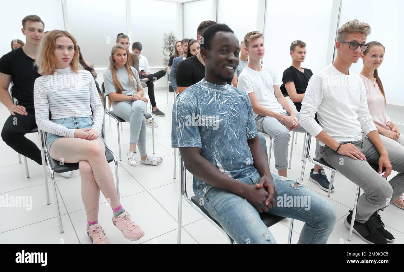 group of diverse young people sitting in a conference room Stock Photo ...