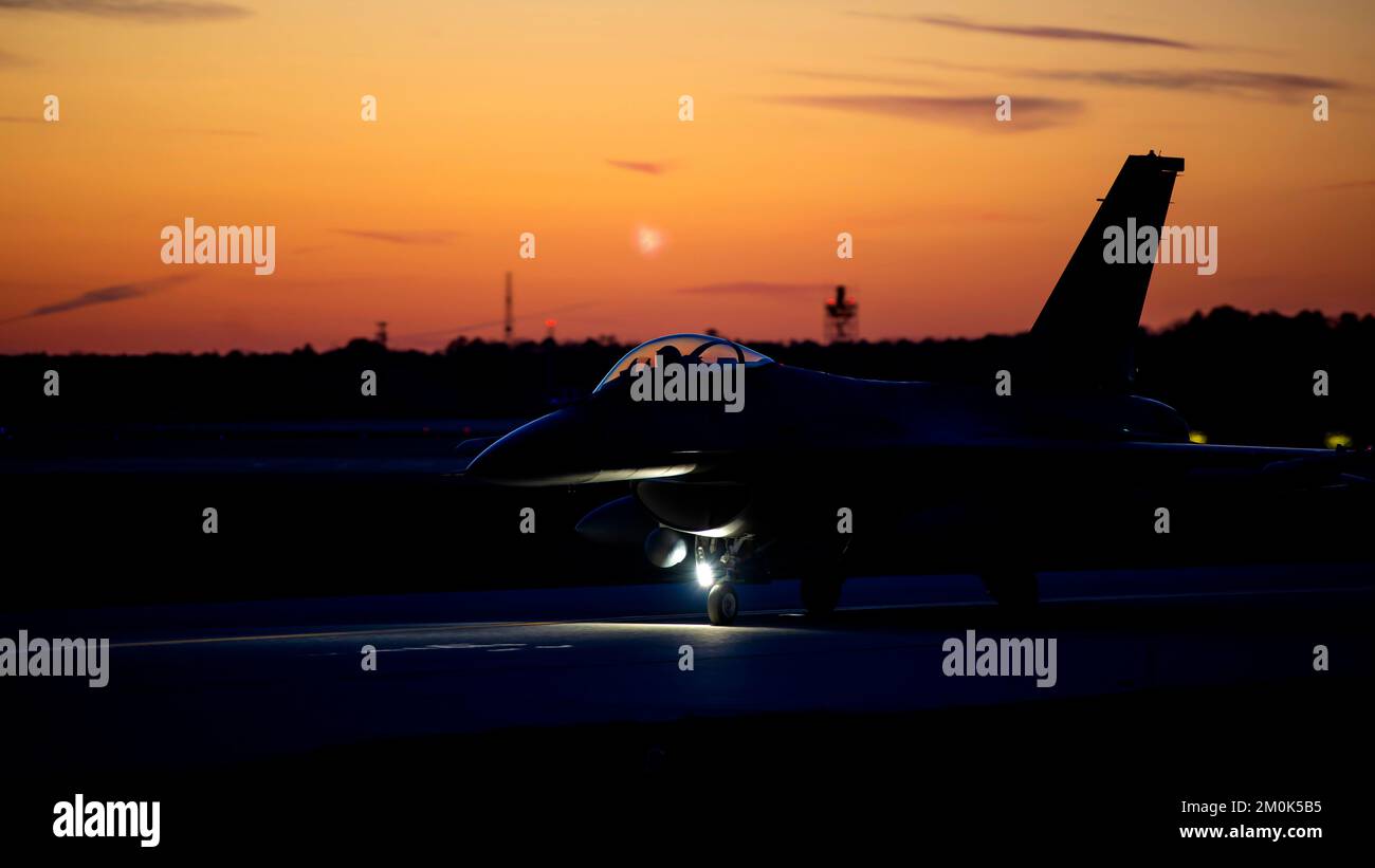 A U.S. Air Force F-16C Fighting Falcon pilot, from the 177th Fighter Wing of the New Jersey Air National Guard, taxis down a runway in preparation for a night flying mission Dec. 1, 2022, at the Atlantic City International Airport, Egg Harbor Township, New Jersey. The night flying was conducted to train pilots for safe and effective night operations.  (U.S. Air National Guard photo by Senior Airman Hunter Hires) Stock Photo