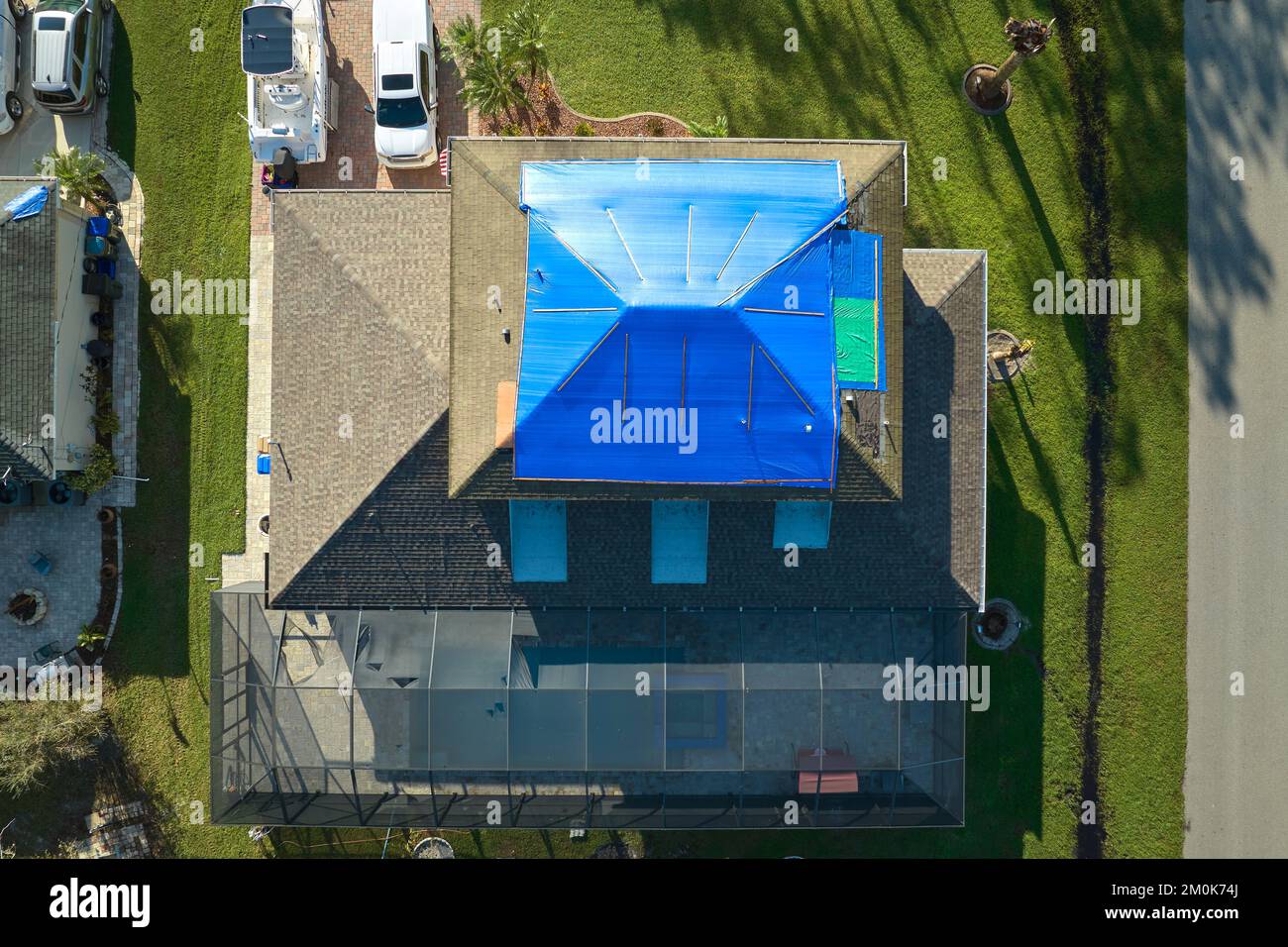 Top view of leaking house roof covered with protective tarp sheets
