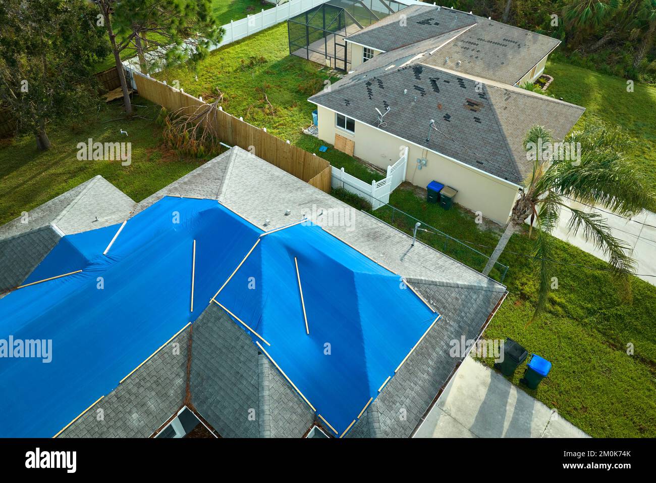 Top view of leaking house roof covered with protective tarp sheets
