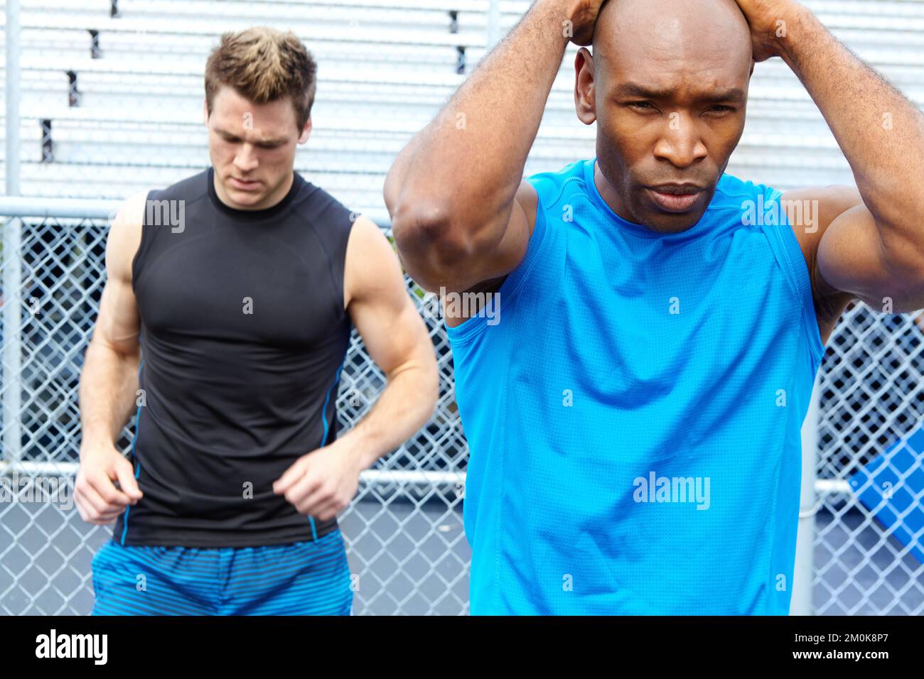Warming up before the race. two male athletes wearing sports clothing ...