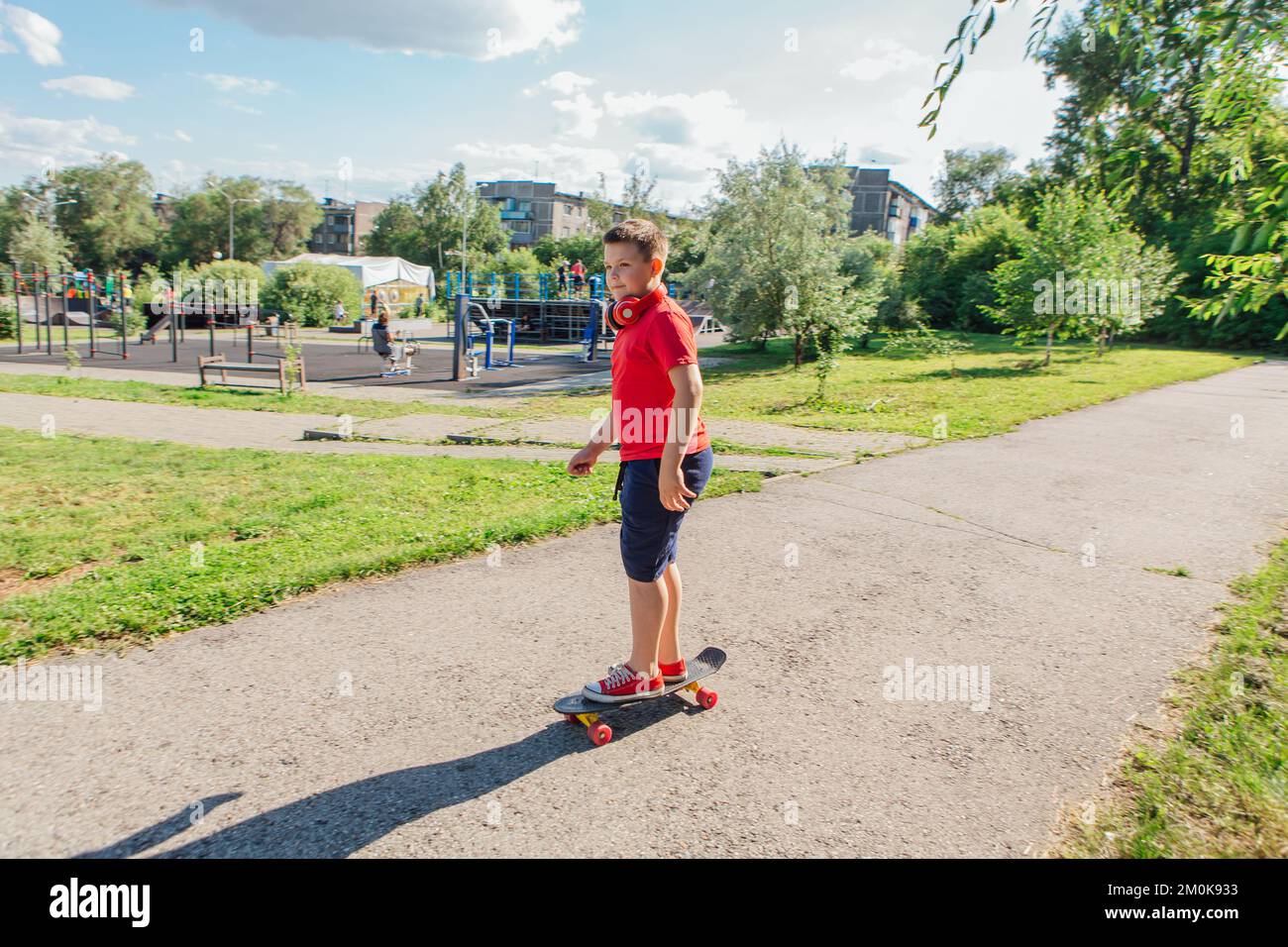 Chubby ten years old boy spends free time training skating in the city park. Cute nice boy
