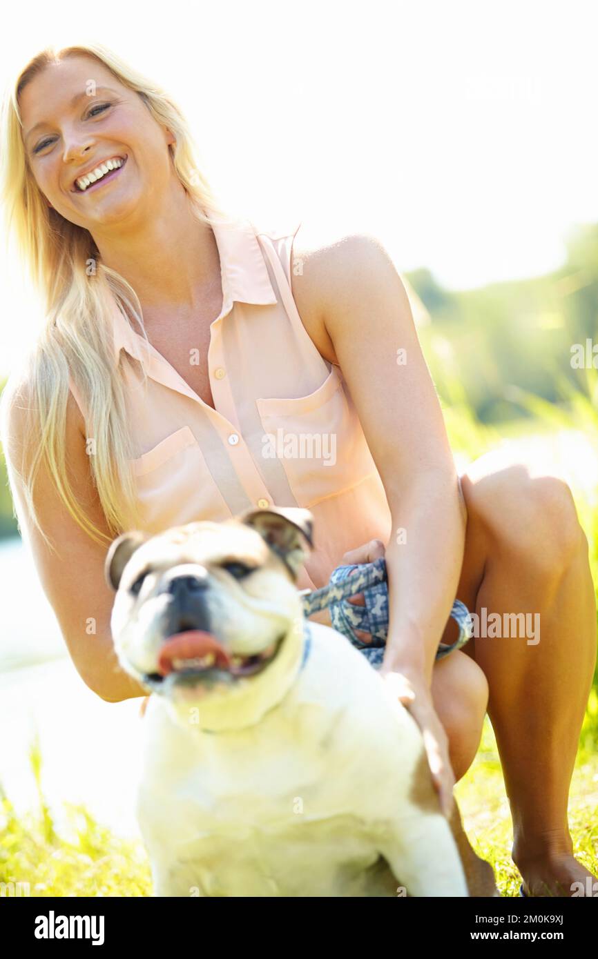 I love my dog. Portrait of a smiling blonde woman outside with her bulldog. Stock Photo