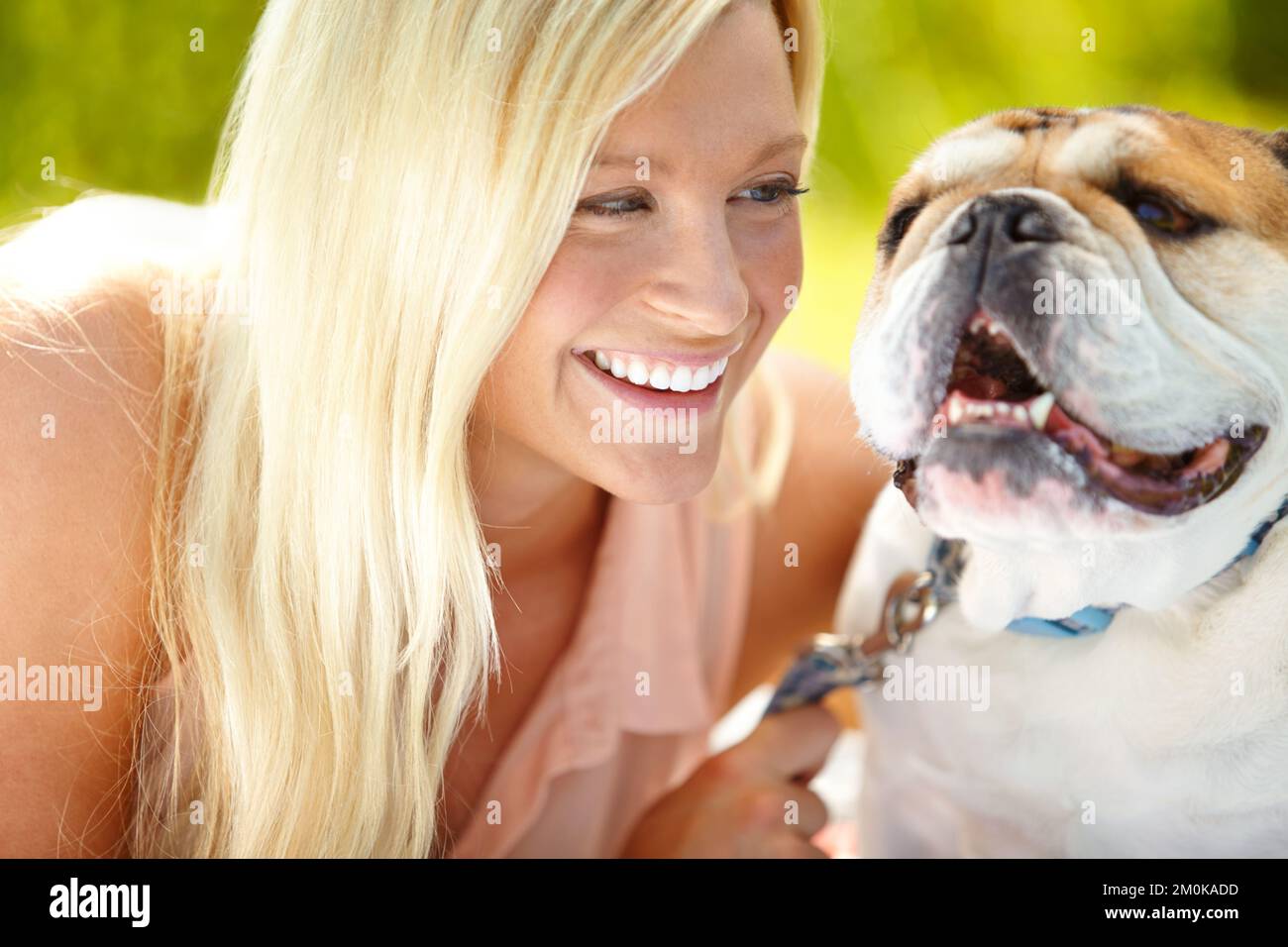 We both love the sunshine. Portrait of a happy dog with his owner looking at him lovingly. Stock Photo