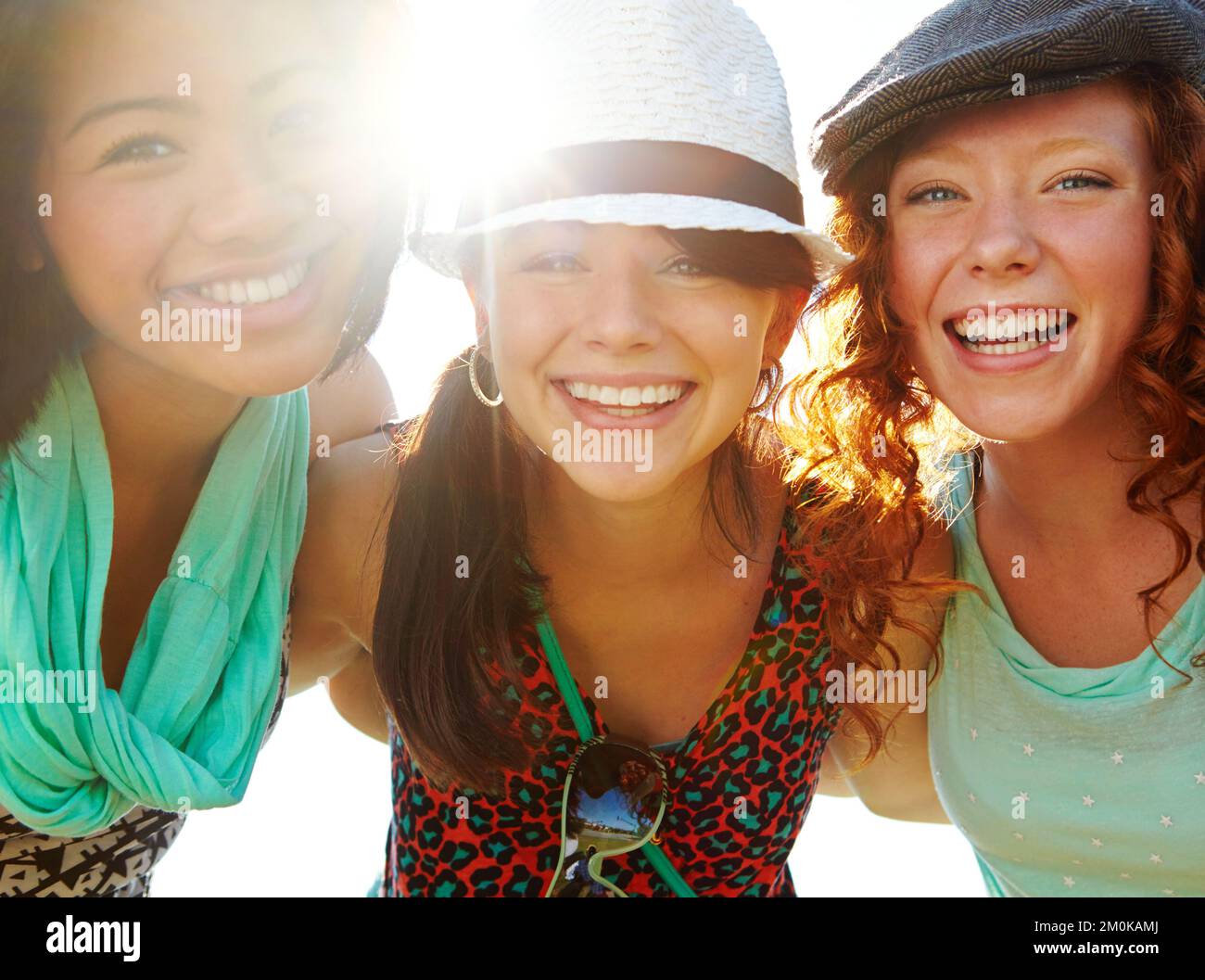 Precious friendship moments. Closeup shot of a group of teenage girls smiling with their arms around each others shoulders. Stock Photo