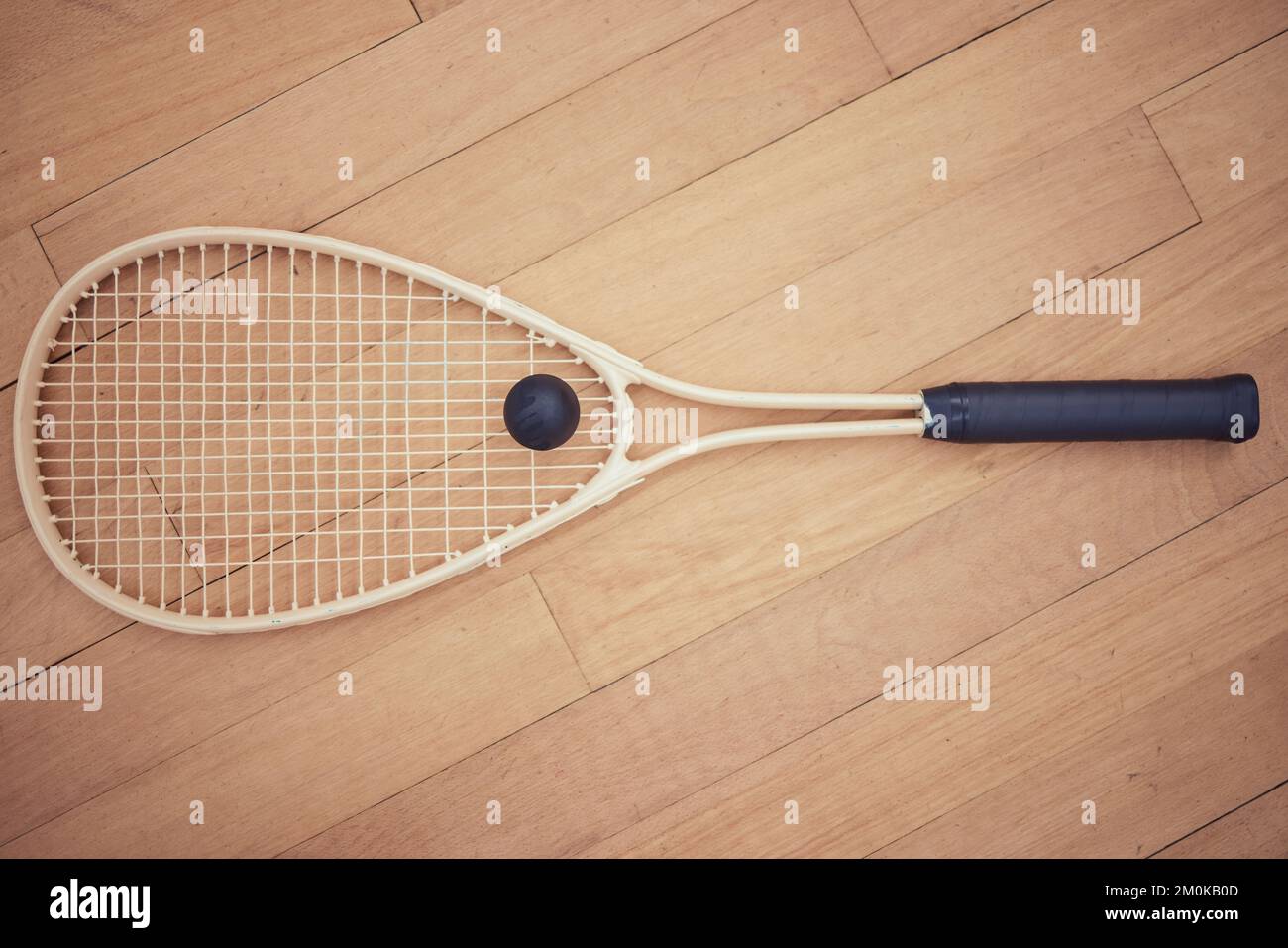Above view of squash gear equipment on wooden floor in empty court in sports centre with