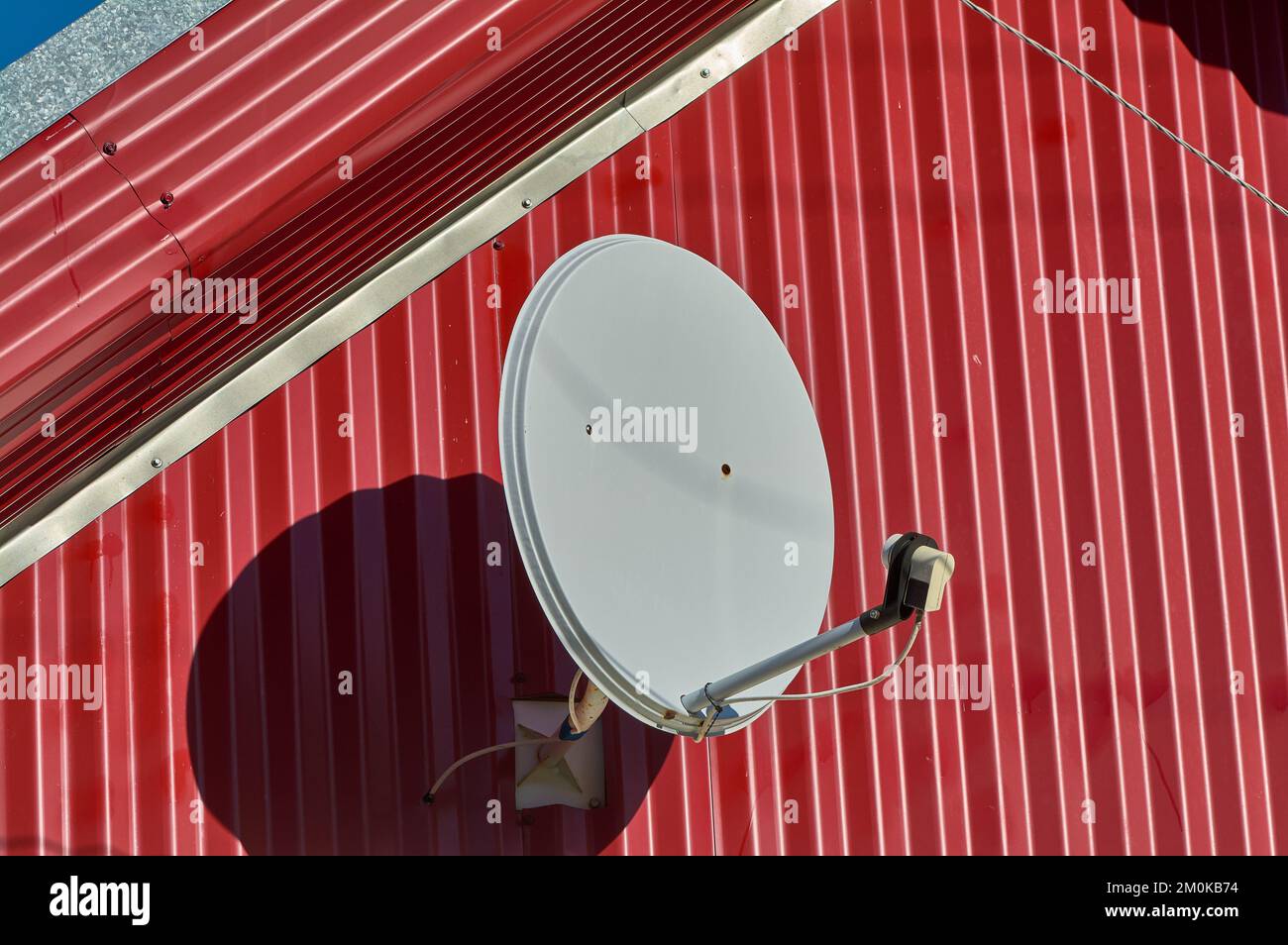 A satellite dish is hanging on the wall of the house Stock Photo Alamy