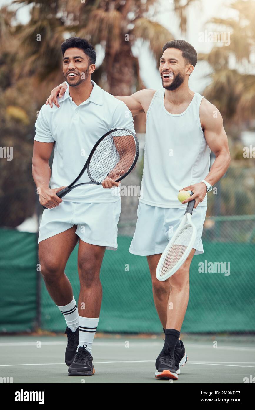 Full length two ethnic tennis players holding rackets and bonding